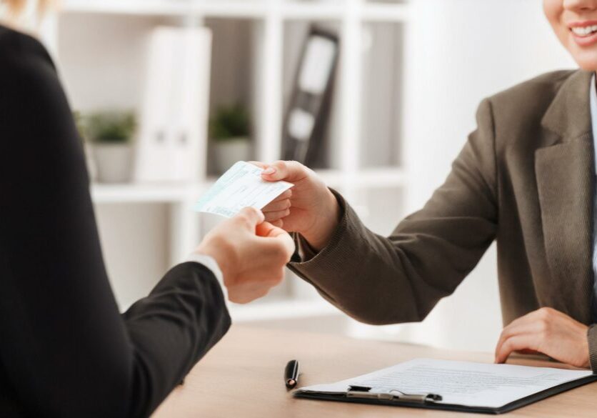 Businesswoman Giving Cheque To Her Colleague