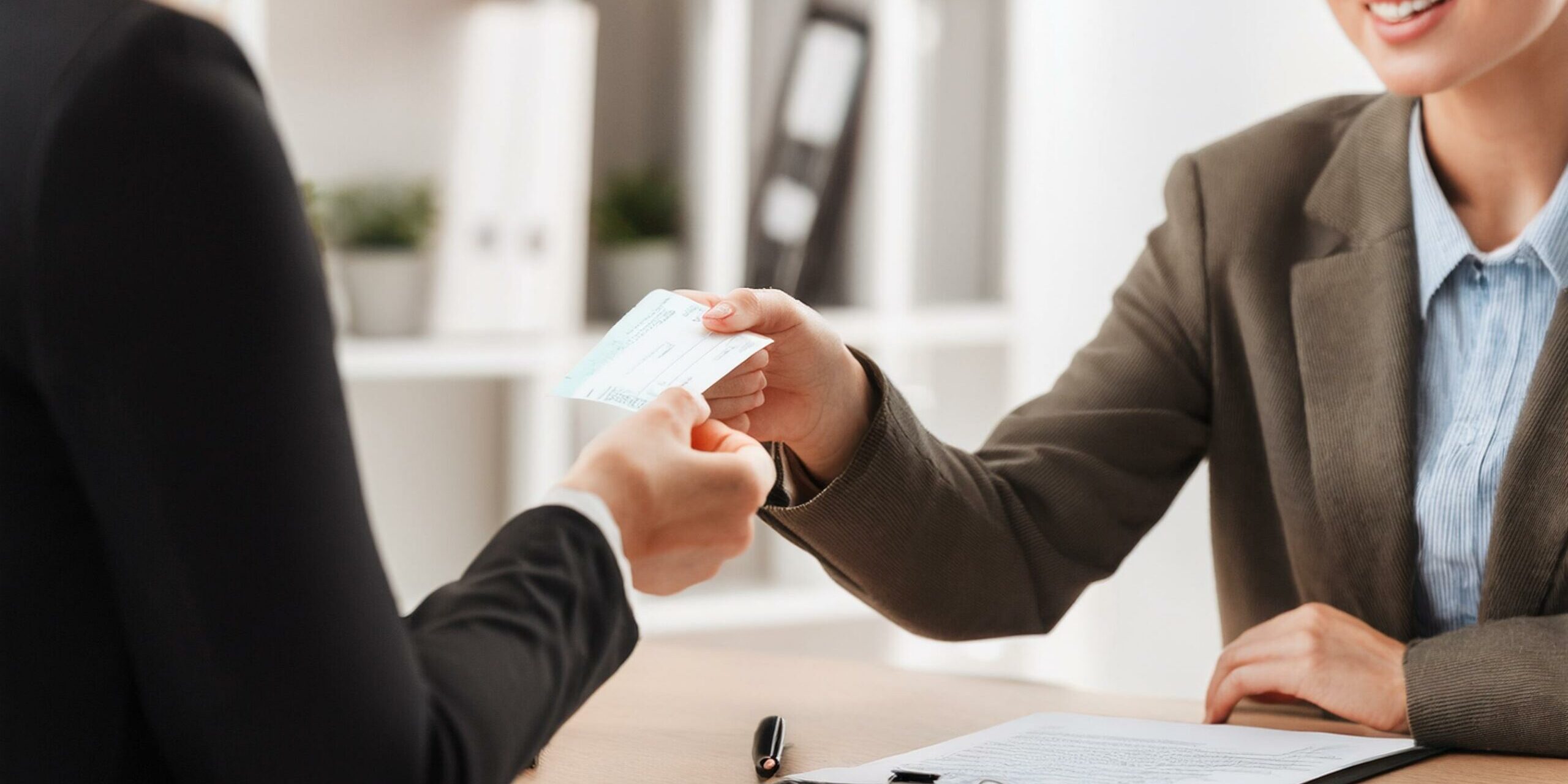 Businesswoman Giving Cheque To Her Colleague