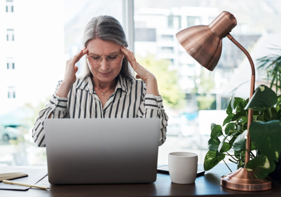 Business woman, headache and stress on computer for payroll processing, mistake or error of human resource payroll. Mature worker or boss on laptop with migraine, pain or health risk in career, job and office.