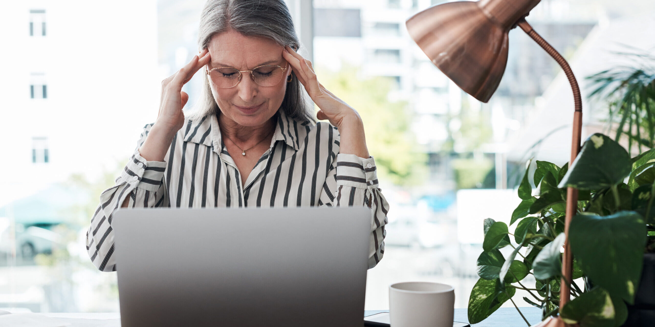 Business woman, headache and stress on computer for payroll processing, mistake or error of human resource payroll. Mature worker or boss on laptop with migraine, pain or health risk in career, job and office.